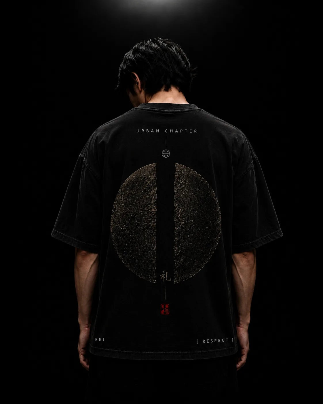Reverse view of a model wearing the oversized black REI artifact, showcasing the monumental fractured obsidian circle rendered in ultra-fine high-density DTG print. A sacred central divide and ceremonial symbols embody the Bushido virtue of Respect, while the heavyweight silhouette and soft vintage wash emphasize the garment's premium construction.